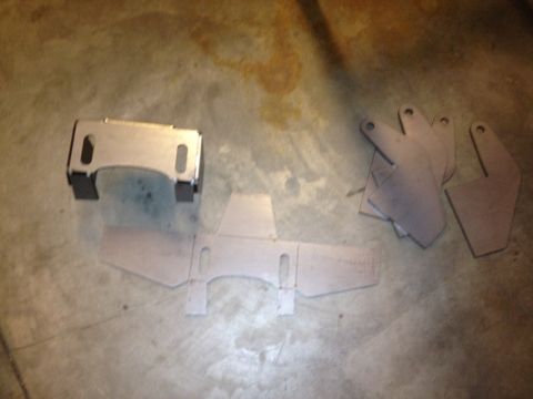 1965 Ford Mustang - Several uninstalled metal parts are arranged on a floor.