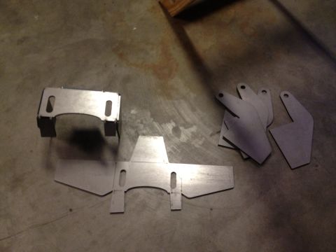 1965 Ford Mustang - Various metal components are arranged on a textured concrete surface.