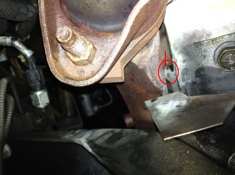 1993 Ford Bronco - Close-up view of an exhaust manifold bolt, with a red circle indicating a specific area of interest.
