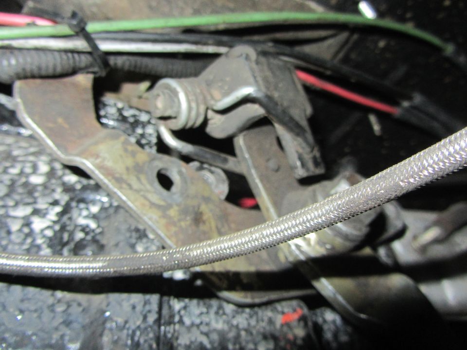 Close-up of a transfer case linkage with cables and metal brackets