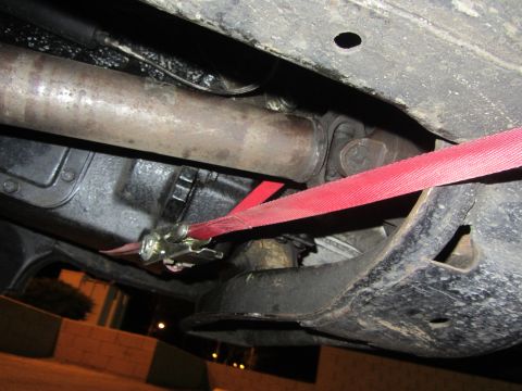 1997 Dodge 3500 - Underside view of a vehicle's drivetrain components secured by a red strap.