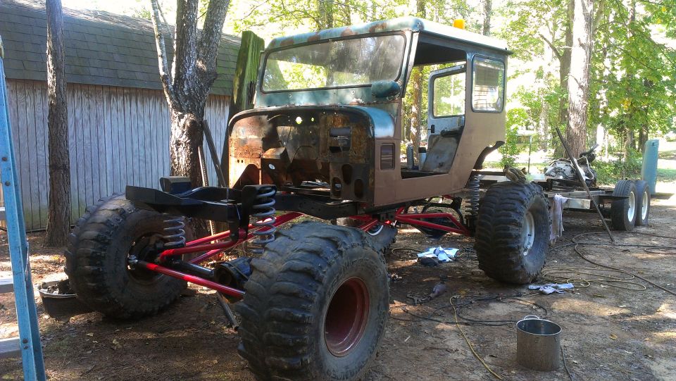 Custom off-road vehicle chassis with large tires and exposed suspension, side view
