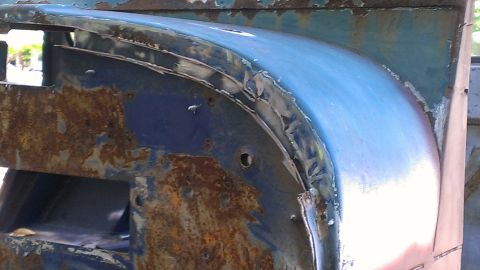 1978 Ford Bronco - This close-up shows significant rust and damage on a vehicle's fender, indicating it's a part needing repair.
