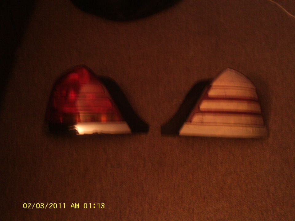 Two Crown Victoria taillight assemblies on carpet, one stock red, one with lightened/covered lens.