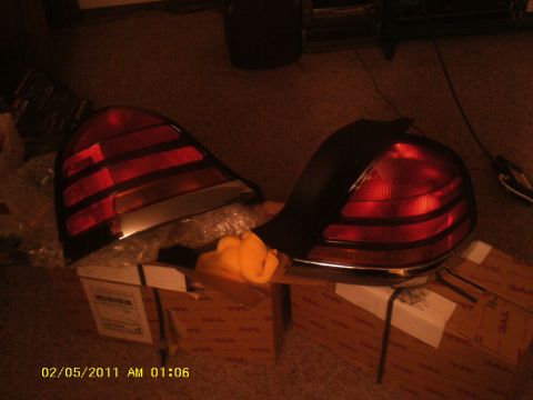 1998 Ford Crown Victoria - A pair of vehicle tail lights are shown resting on boxes, with a timestamp of 02/05/2011.
