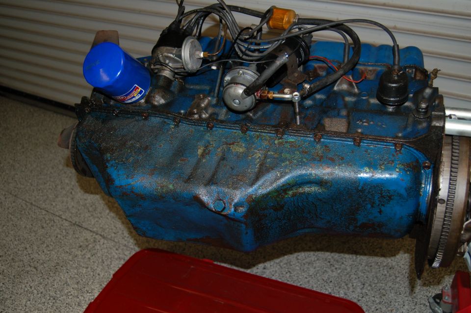 Blue engine block with oil filter and distributor, showing rust and grime