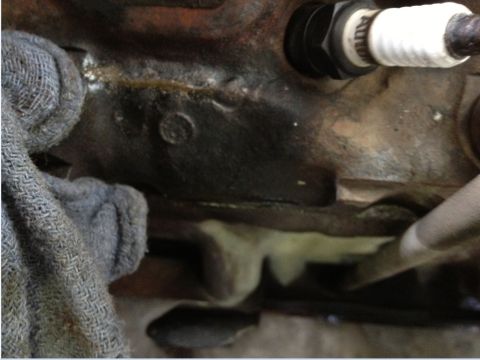 1993 Ford Bronco - Engine block detail showing a spark plug and some fluid residue.
