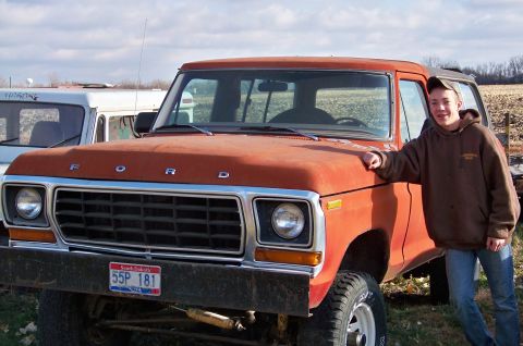 1978 Ford Bronco - A young man poses with a weathered orange Ford Bronco, with another vehicle visible in the background.