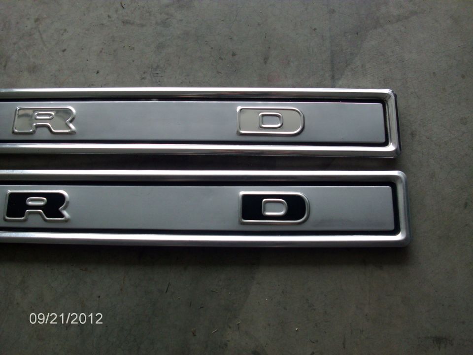 Two Ford emblems, one with a silver outline and one with a black outline