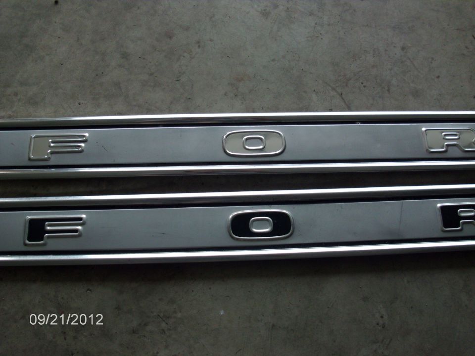 Two metal door sill plates with 'FORD' lettering embossed on them