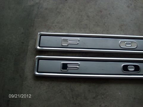 1979 Ford F-150 - Close-up of two Ford F-150 emblems, showing variations in their design and finish.