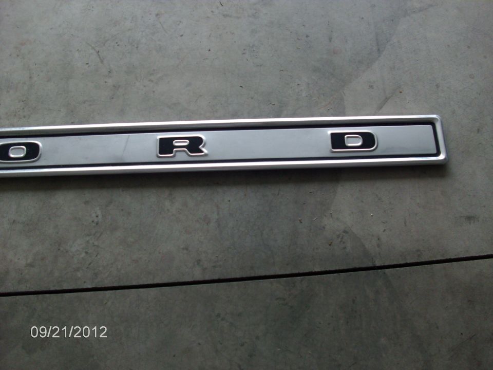 Close-up of a silver trim piece with black letters spelling 'ORD'
