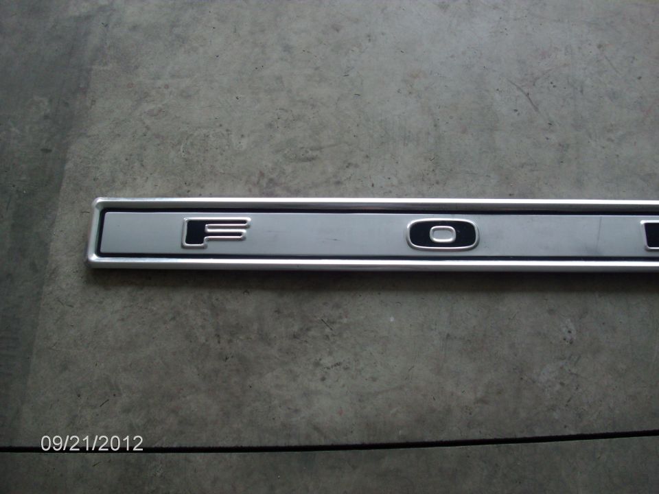 Silver trim piece with raised black letters spelling F-O-R-D