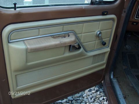 1979 Ford F-150 - Interior view of a 1979 Ford F-150 door panel, showing the tan upholstery and window crank.