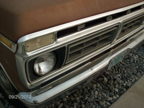 1979 Ford F-150 - Close-up of the front grille and headlights on a brown 1979 Ford F-150 truck.