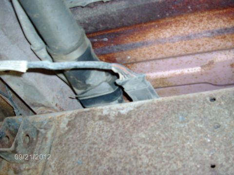 1979 Ford F-150 - Close-up view of the fuel filler neck and wiring harness attached to the undercarriage of a vehicle.