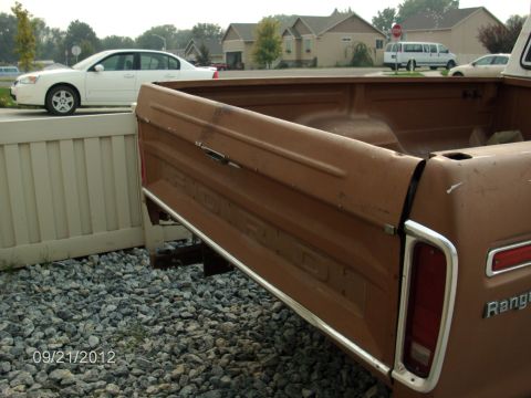 1979 Ford F-150 - The rear of a brown pickup truck, identified as a Ranger, is shown with chrome trim and visible badging.