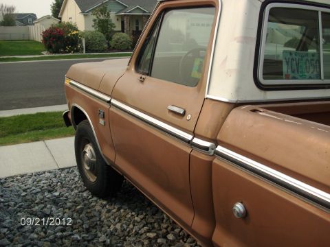 1979 Ford F-150 - A brown 1979 Ford F-150 pickup truck is parked on a gravel driveway, viewed from the side.