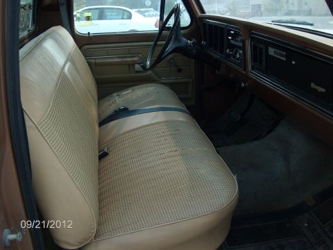 1979 Ford F-150 - The interior of a truck shows tan seats and the dashboard with a 'Ranger' emblem visible on the passenger side.