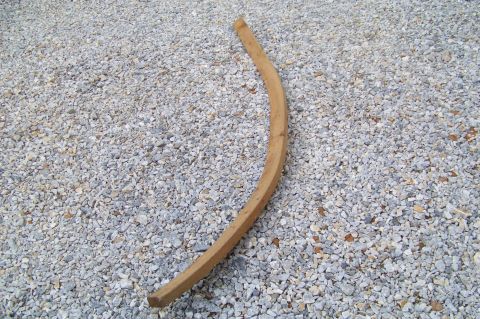 1994 Ford F-150 - A curved wooden piece lies on a bed of gravel, with a website watermark visible in the lower right corner.