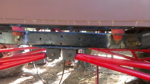 1978 Ford Bronco - Close-up view of the undercarriage, highlighting red suspension parts and the vehicle's frame.