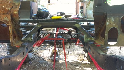 1978 Ford Bronco - Underbody view of a vehicle frame and suspension system, likely in a workshop setting.