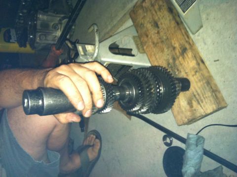 1993 Ford Probe - Close-up of transmission gears being held by a hand, with shop equipment visible.