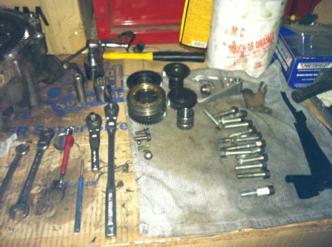 1993 Ford Probe - Various automotive parts and tools are organized on a workbench, ready for assembly or repair.