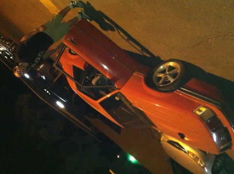 1993 Ford Probe - An orange sports car is parked on a street at night.