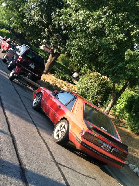 1993 Ford Probe - A red coupe with a spoiler and aftermarket wheels is parked on a street, with other vehicles behind it.