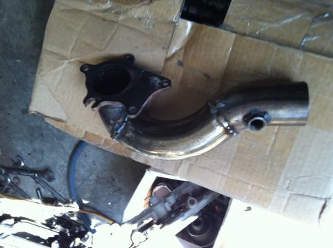 1993 Ford Probe - Custom exhaust pipe with a bolted flange, resting on cardboard.