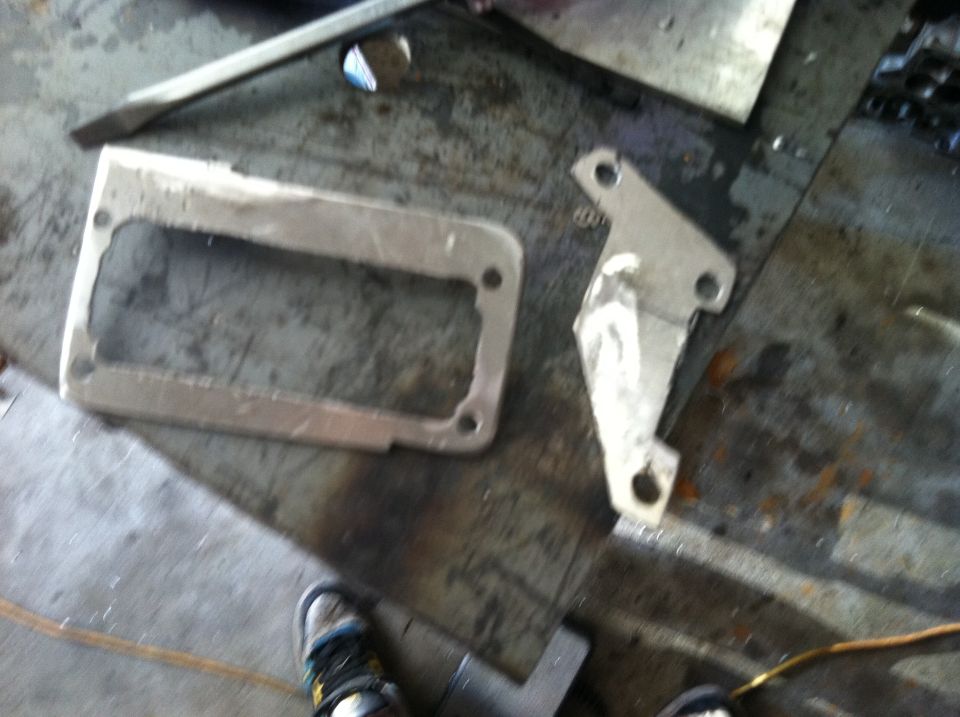 Metal bracket and rectangular frame with cutouts on a workbench