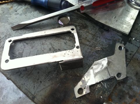 1993 Ford Probe - Metal fabrication parts and tools are laid out on a workbench surface.