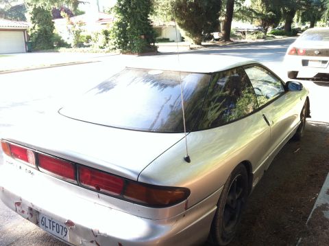 1993 Ford Probe - A silver 1993 Ford Probe is parked on a residential street next to another vehicle.