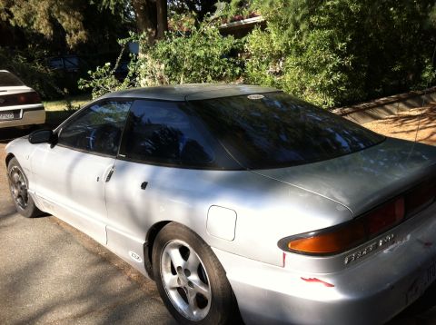 1993 Ford Probe - A silver 1993 Ford Probe is parked on a street, viewed from the rear quarter angle.