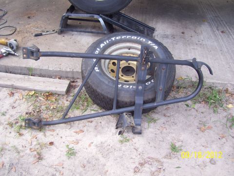 1990 Ford Bronco - Detached rear spare-tire carrier bracket assembly with a BF Goodrich All-Terrain T/A tire, dated 09/18/2012.