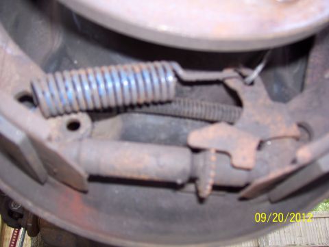 1990 Ford Bronco - This photo shows a close-up view of a vehicle's brake drum assembly, including a spring and other mechanical components.