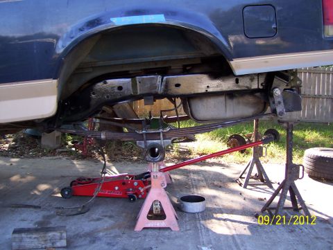 1990 Ford Bronco - Vehicle's rear suspension and undercarriage are visible while it is supported by jack stands.