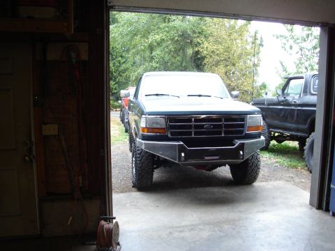 1989 Ford Bronco - Front view of a Ford F-Series truck with an aftermarket bumper, parked inside a garage.
