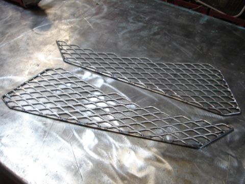 1989 Ford Bronco - Two diamond plate metal pieces are shown on a metal workbench, possibly for a custom vehicle modification.