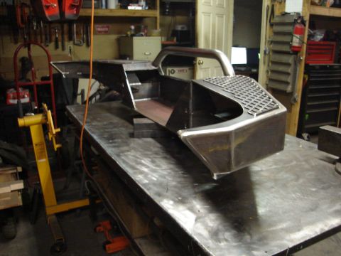 1989 Ford Bronco - Custom fabricated winch bumper, likely for an off-road vehicle, sits on a metal workbench.