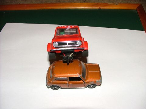 1980 MINI Cooper - Two toy cars are stacked on top of each other against a white background.