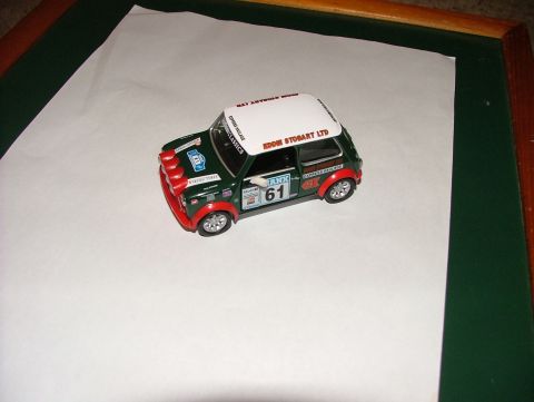 1980 MINI Cooper - A detailed model car, possibly a MINI Cooper, is displayed on a white surface.