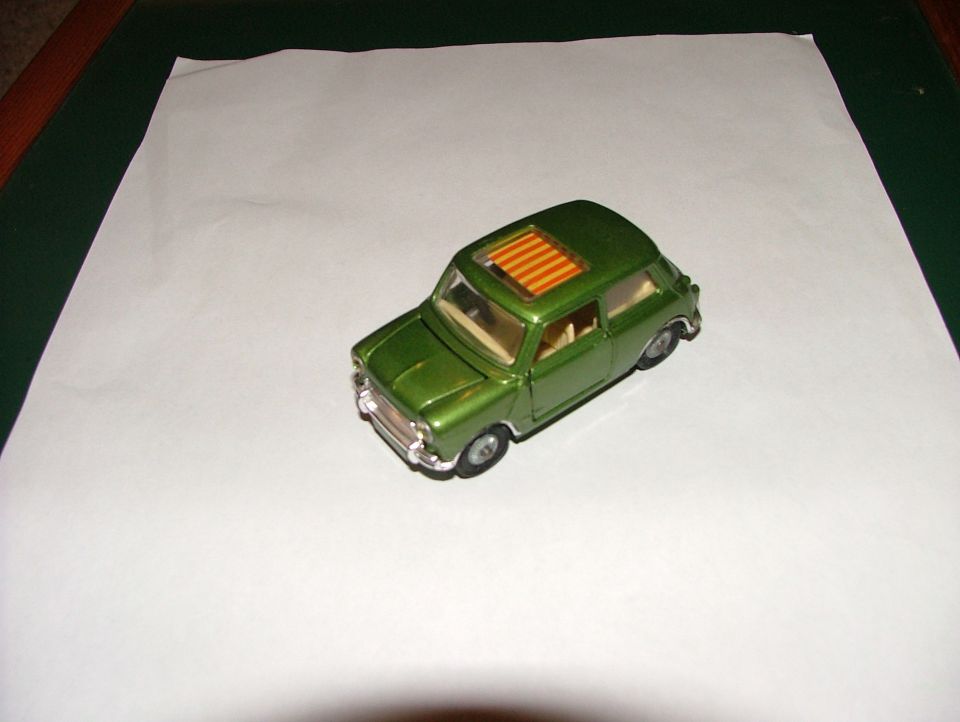 Green toy car with orange striped sunroof, viewed from a 3/4 front angle