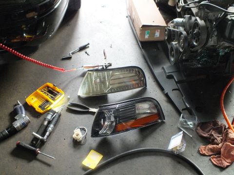 2003 Ford Crown Victoria - Two corner lamp assemblies surrounded by power tools and a DeWalt drill-bit set on shop floor.
