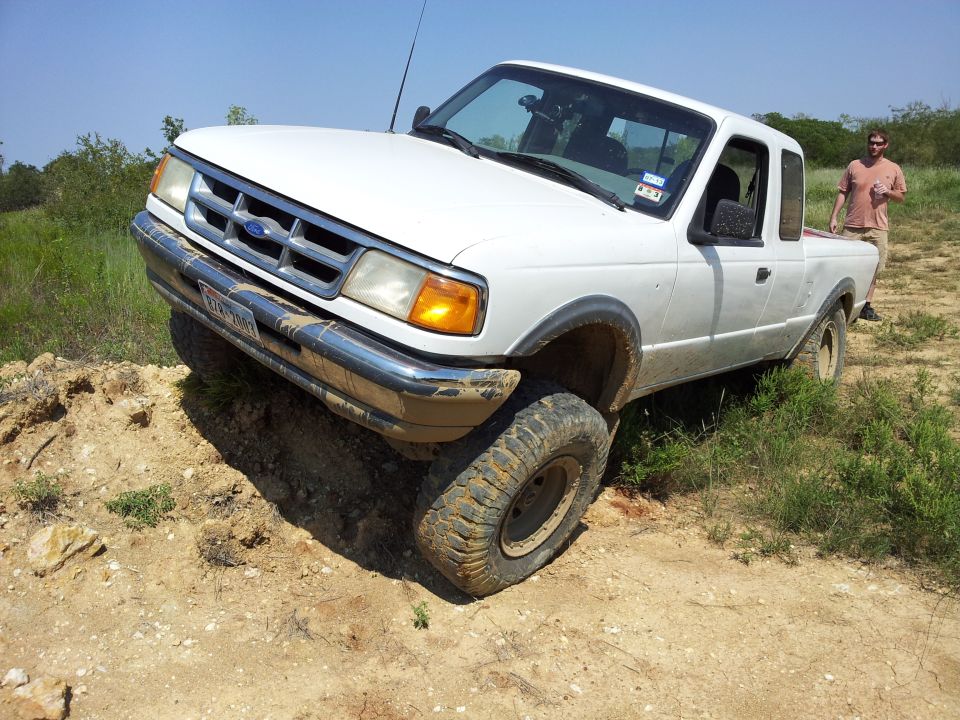 1994 Ford Ranger pickup truck with front wheel on dirt mound