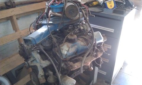 1974 Oldsmobile 442 - An engine assembly, likely from a classic car, is shown in a workshop setting.