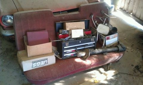 1974 Oldsmobile 442 - Car interior with a toolbox, parts, and boxes on the bench seat.
