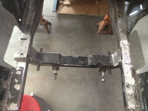 1965 Ford Mustang - Car frame section with crossmember and jack stands supporting it.