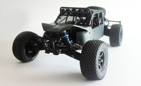 1986 Ford Bronco - This black off-road buggy features a roll cage and exposed suspension components.